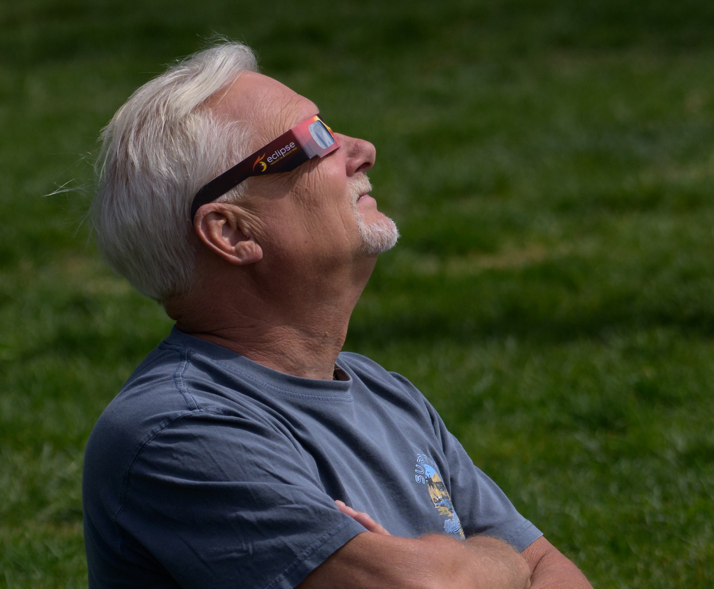 Hombre observando un eclipse solar parcial con gafas protectoras de cartón
