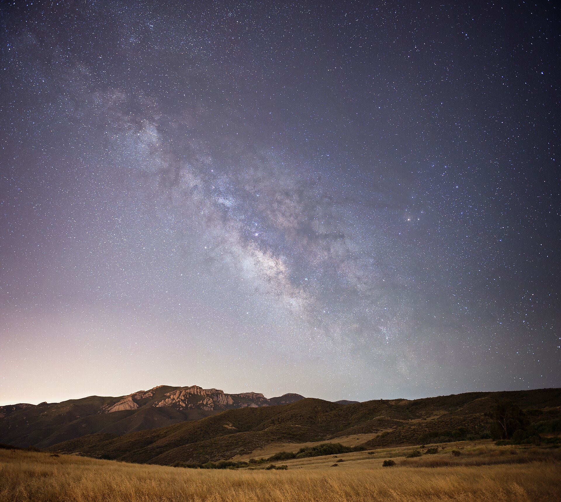 Vía Láctea sobre colinas y montañas en una noche estrellada